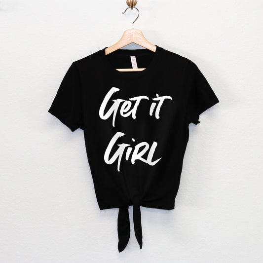 A black front-tie crop top with bold white text that reads "Get it Girl." The top features a stylish front tie, adding a trendy and empowering touch to this casual yet chic piece.